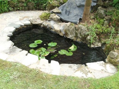 Small pool with discreet SAFADECK pond grid below deck fitted by Pond Safety Systems, Ireland